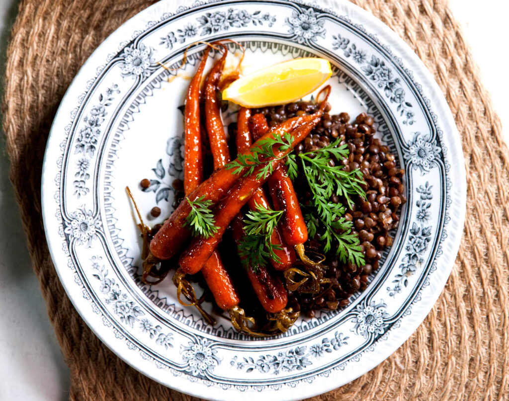 An overhead image of caramelised carrots on a bed of puy lentils.