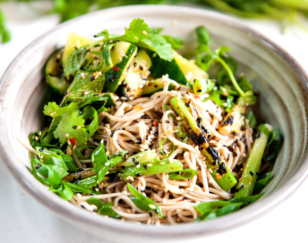 A refreshing looking bowl of soba noodles with greens.