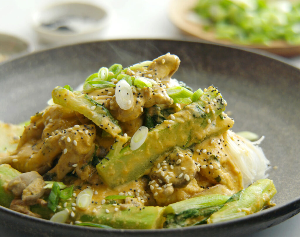 A serving bowl presented nicely with a heaped portion of creamy veggie stirfry with vegan 'chicken' strips.