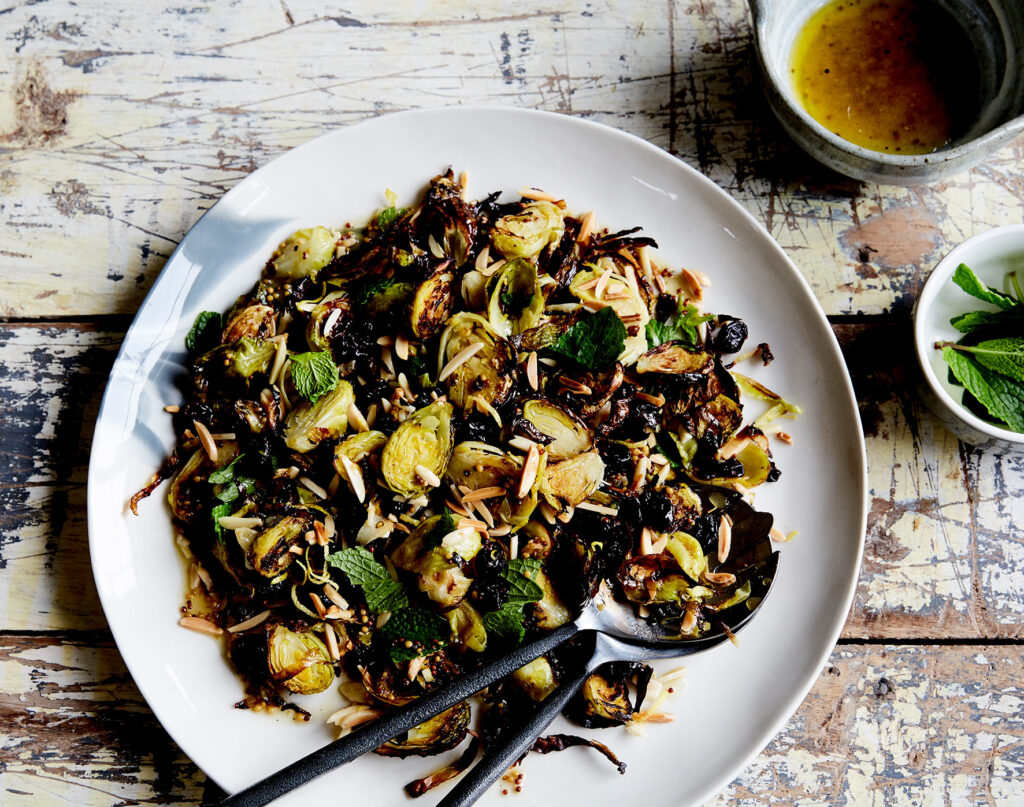 An overhead shot of a plate full of salad with charred and halved Brussels sprouts.