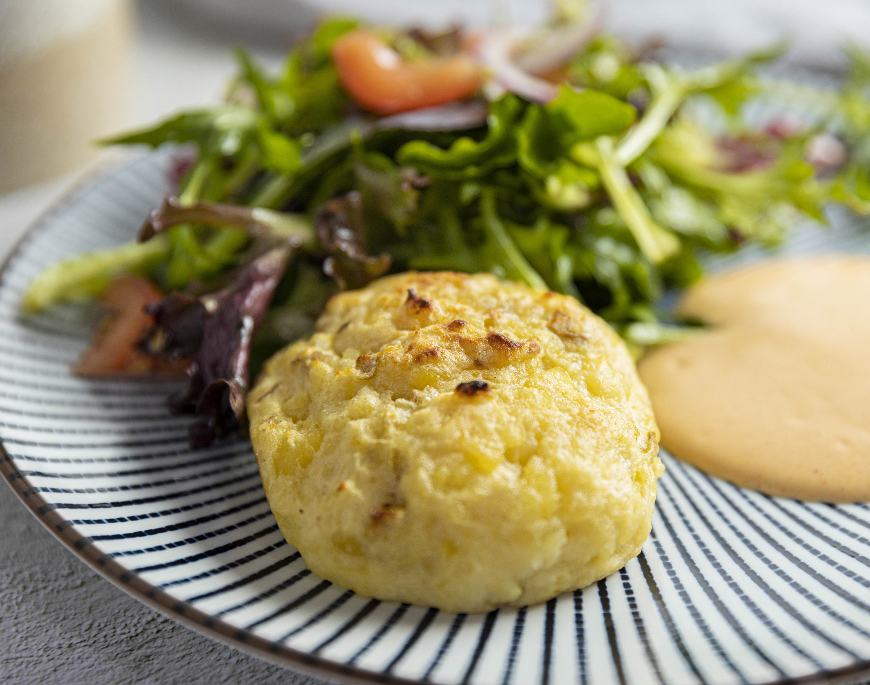 vegan gnocchi on plate with green salad on side