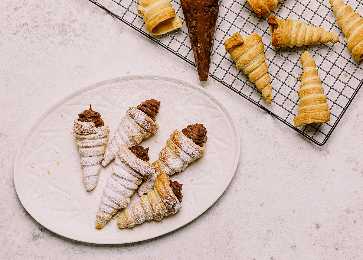 Custard Cream Horns on a plate with icing sugar on top