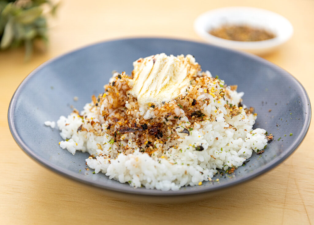 A plate of rice topped with seasonings and a dollop of oat butter.