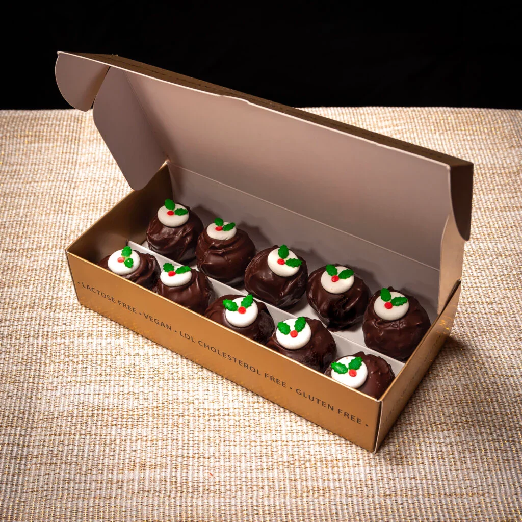 Image of a box of brandy truffles with the lid open. The truffles have been decorated like Christmas puddings.