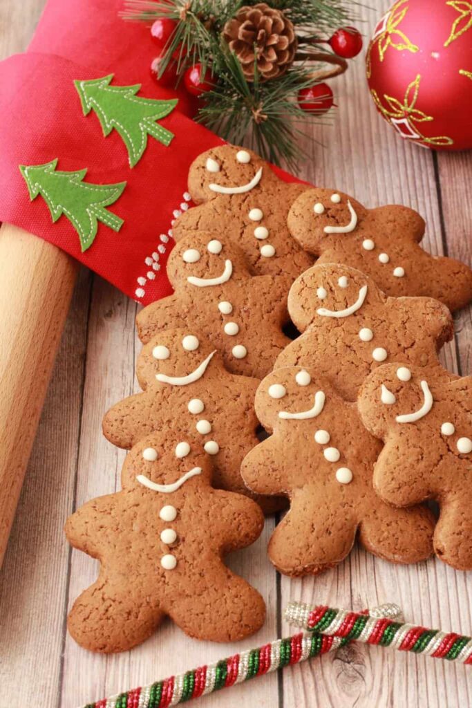 An overhead image of smiling gingerbread men stacked in the shape of a Christmas tree. 