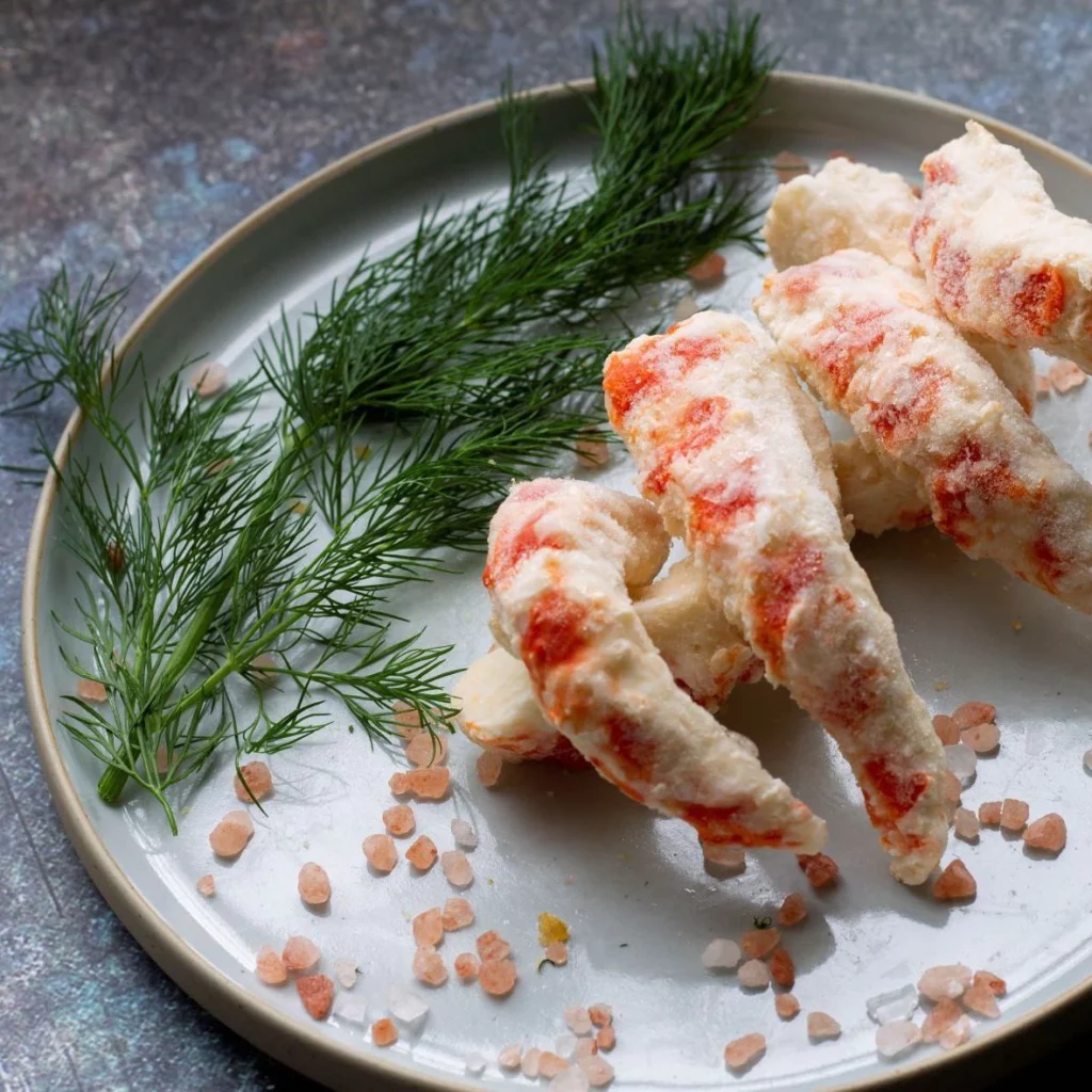 Prawns on a plate with a garnish of herbs and pink rock salt.