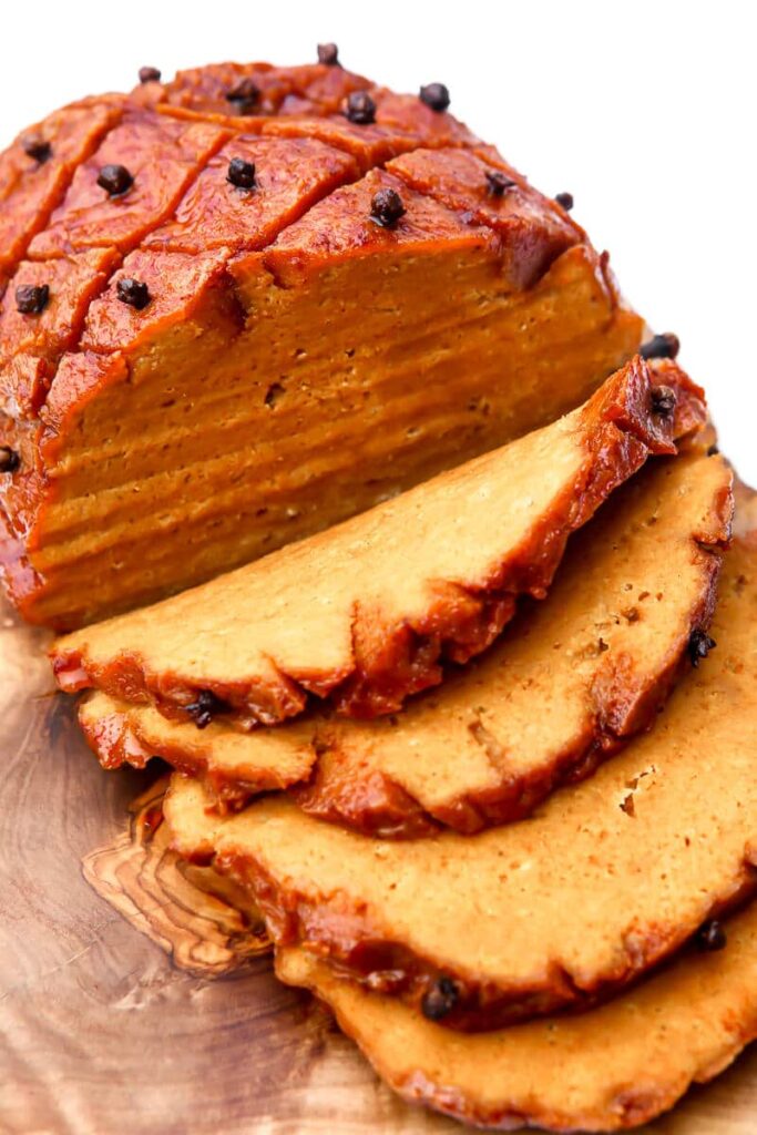 Overhead close up image of vegan ham which has been sliced to reveal the cente.