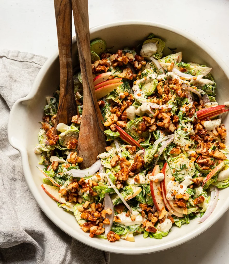 Creamy salad in a bowl with wooden salad servers.