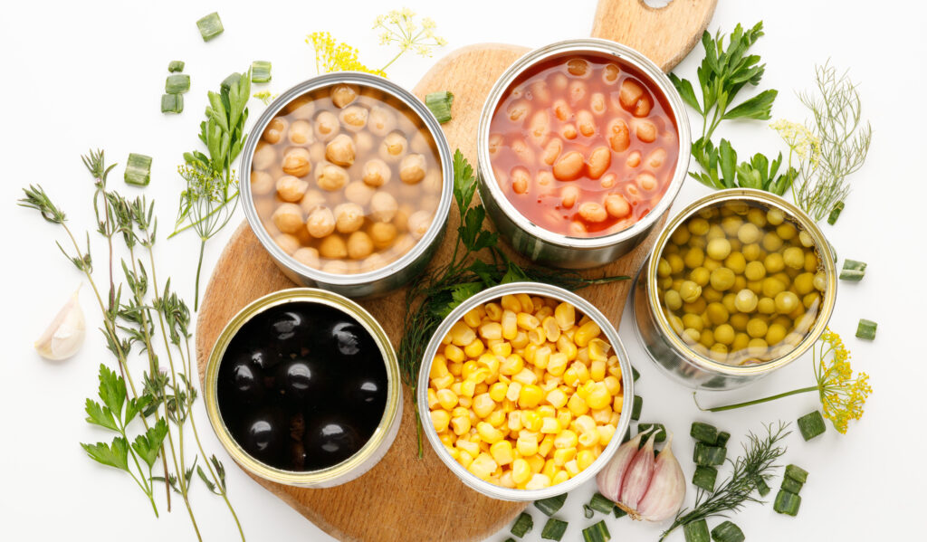 Tinned veg and beans on a white background.