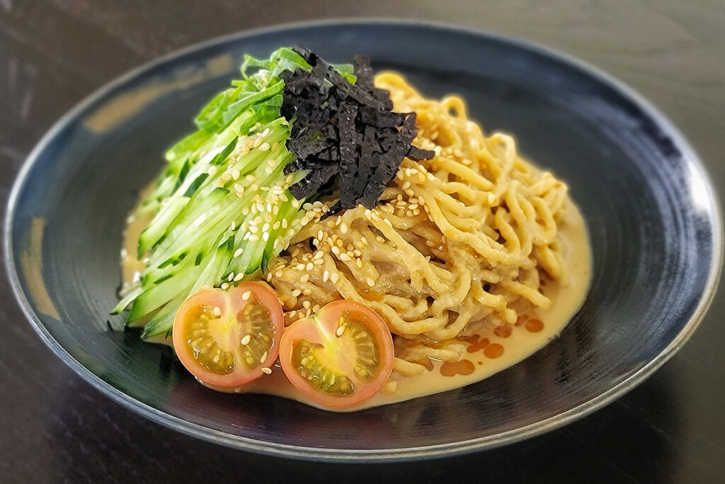 A bowl of ramen noodles in a creamy broth.