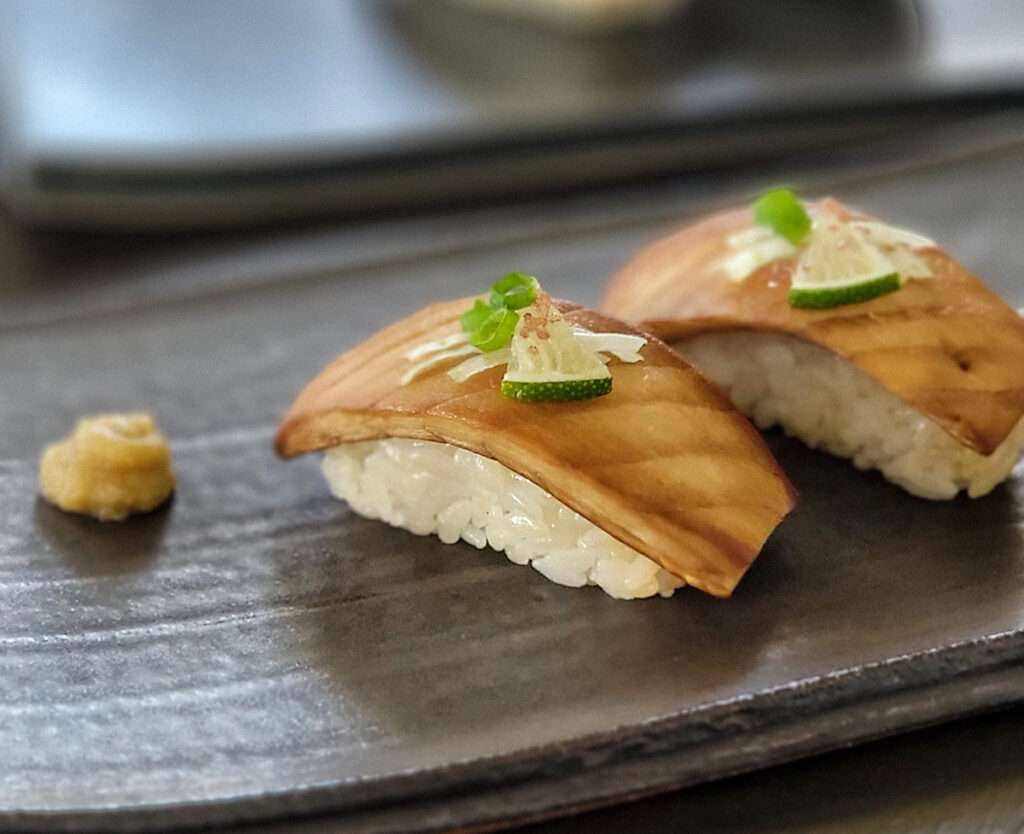 Sushi on a serving tray topped with 'fish' made from king oyster muyshrooms.