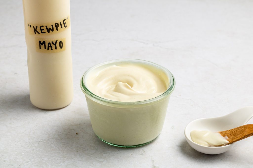 A small tub of Japanese mayo sits on a bench beside a squeeze bottle labelled "Kewpie Mayo".