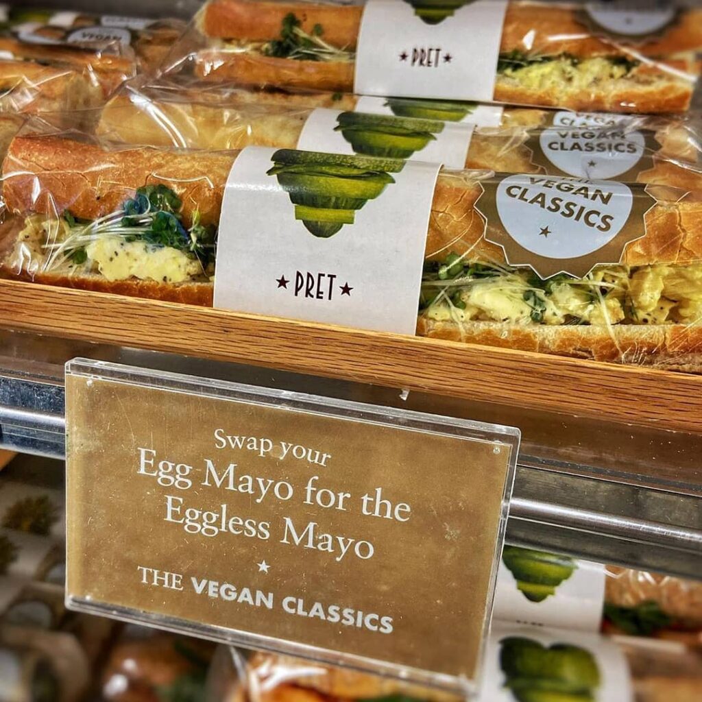 A view of grab and go baguettes in a cafe, with a sign to swap your egg option for an eggless one.